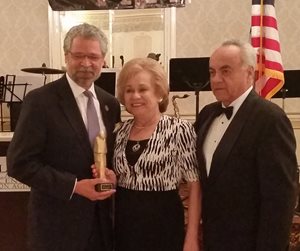 Hostos President Dr. David Gomez. 1 woman. 1 man. statue.