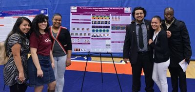 4 women, standing. 2 men, standing. smiling.