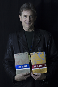 Professor Raymond Healey holding books The Iliad and The Odyssey.